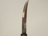 a close up of a person holding a knife on top of a wooden table