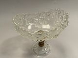 a glass bowl on a stand on a white surface