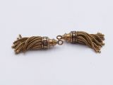 a pair of gold tassels with black and white beads