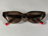 une paire de lunettes de soleil posée sur une surface blanche