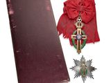 un livre rouge orné d'une croix, à côté d'une médaille