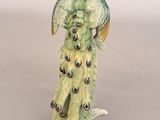 a figurine of a peacock on the beach