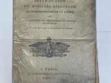 un vieux livre posé sur une table à côté d'un mur blanc