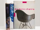 deux livres posés sur une étagère à côté d'un fauteuil