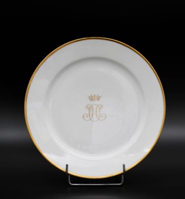 une assiette blanche et dorée ornée d'une couronne