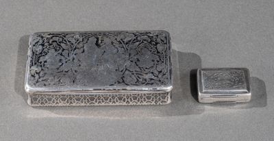 deux boîtes en argent posées l'une à côté de l'autre sur une table