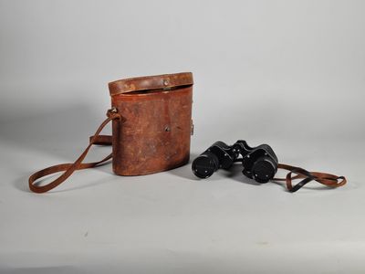 un vieil étui à appareil photo en cuir avec une paire de jumelles