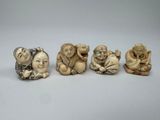 quatre petites figurines sculptées représentant des singes, posées sur une surface blanche