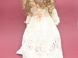 a small doll that is sitting on a pink surface