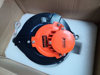 une borne d'incendie orange et noire posée à l'intérieur d'une boîte en carton