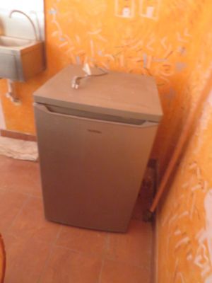 un petit réfrigérateur dans un coin d'une petite salle de bains