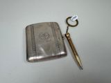 a silver case with a pen and a key in it