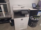 a white printer sitting next to a black and white printer