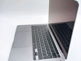 a silver laptop with a black keyboard on a white surface