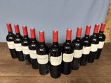 six bottles of red wine lined up in a row on a wooden table