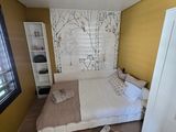 a bedroom with a bed, cupboards, and a window
