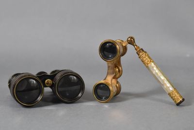 une paire de jumelles anciennes et un télescope posés sur une table