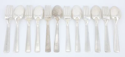 cinq fourchettes et cinq cuillères sur une table blanche