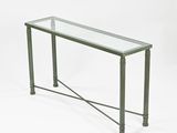 une table en verre avec des pieds en métal et un plateau en verre