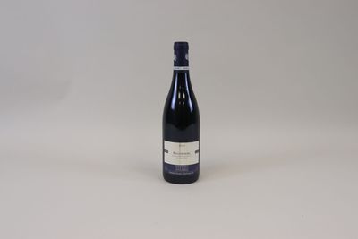 la bouteille de vin est posée sur une surface blanche