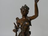 bronze statue of a woman holding a bird and a bird cage
