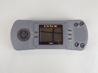 a gray game console with a black screen on a white surface