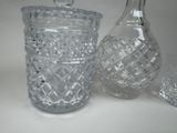 three glass vases and a decanter sitting on a table