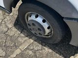 a close up of a flat tire on a white truck