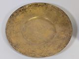 a gold plate sitting on a white table