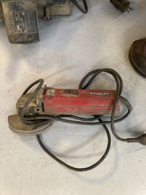 une image représentant une paire de chaussures marron et un outil électrique rouge et noir