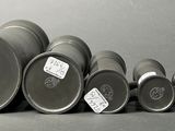 many metal barrels lined up on a gray surface