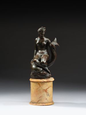 une statue en bronze représentant une femme assise sur un socle en marbre
