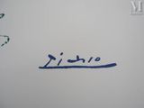 someone is writing on a piece of paper with a blue marker