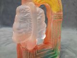 a glass sculpture of a person with a rainbow in the background
