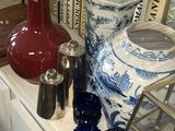 de nombreux vases de toutes sortes posés sur une étagère dans une pièce