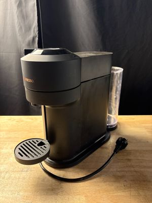 La cafetière est posée sur la table, à côté d'un verre.