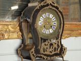 a clock sitting on a shelf in front of a mirror