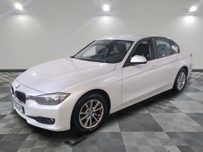 BMW Série 3 berline, blanche, avec des jantes noires et des roues chromées