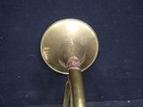 a brass trumpet that is sitting on a blue surface