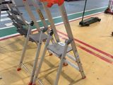 three ladders that are sitting on the floor in a warehouse