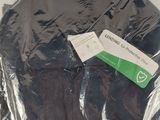 a black t - shirt wrapped in plastic on a table