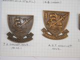 three metal badges are shown on a piece of paper