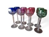 six verres à vin sont alignés sur une surface blanche