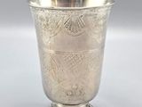 an antique silver cup with a design on the rim
