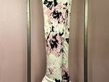 pink and black floral pants hanging on a rack in front of a pink wall