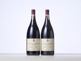 two bottles of red wine sitting on top of a table