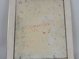 an old picture frame with writing on it sitting on a table