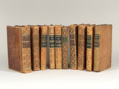 six vieux livres sont alignés sur une surface blanche