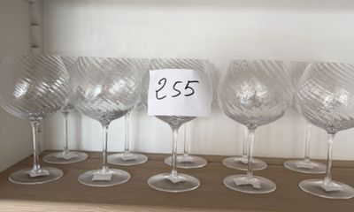six verres à vin posés sur une étagère, avec une étiquette de prix