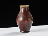 a brown vase sitting on a white table